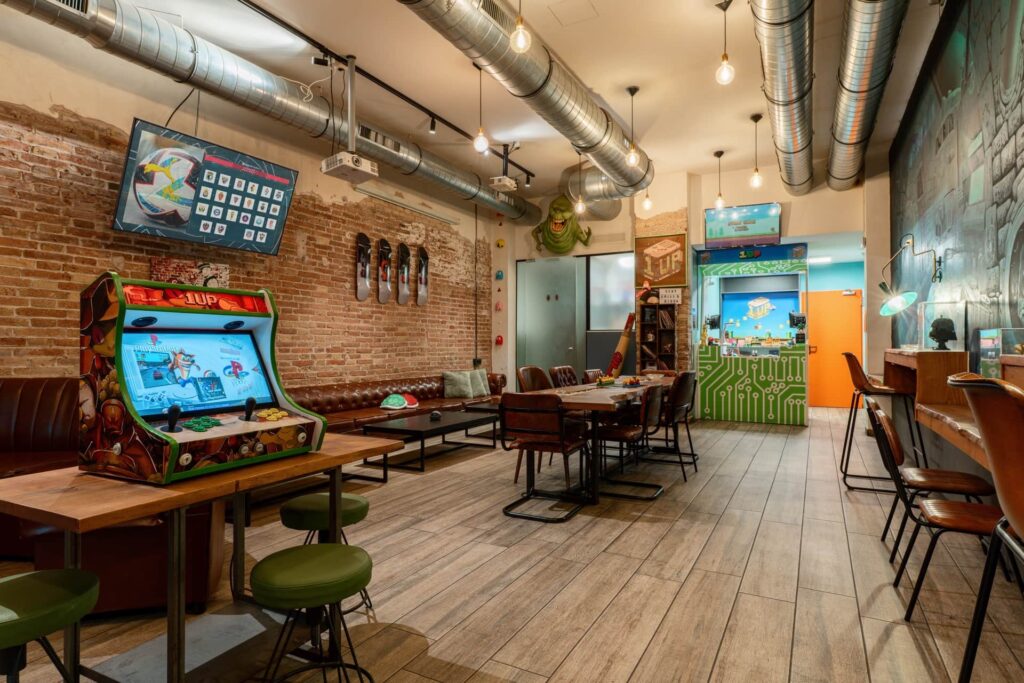 Arkadmaskin och loungezon i social club 1UP Barcelona